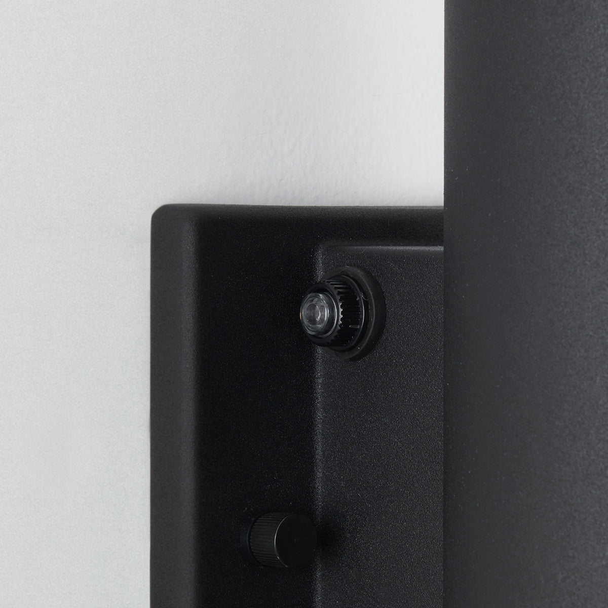 Close-up of the Artika Linea modern indoor-outdoor LED wall light, a black wall-mounted fixture with two round knob controls—one larger above, one smaller below—shown against a white wall.