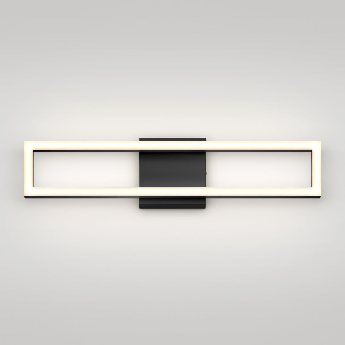 The Artika Dover 27-in Integrated LED 5-CCT Vanity Light Bar features a modern rectangular design with a glowing frame, chrome finish, and black central mounting plate, displayed against a plain light-colored wall.