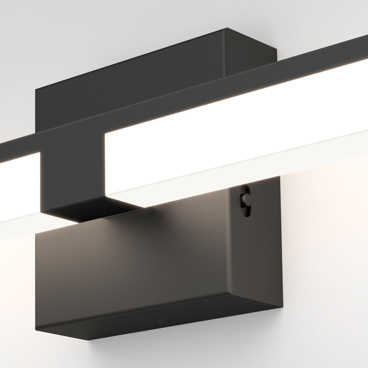 Close-up of the Artika Tivoli modern LED bathroom vanity light 5 CCT, a sleek rectangular black wall sconce with a horizontal white glowing bar and adjustable lighting, mounted on a plain white wall.
