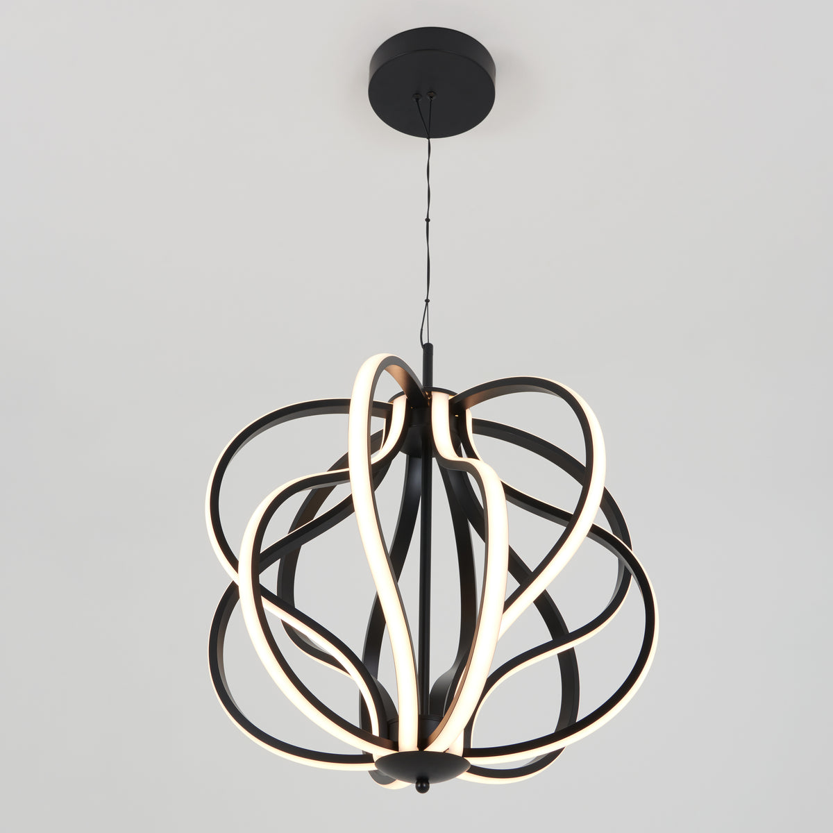 The Artika Meridian LED pendant light features intertwined, curved black metal bands with integrated LED strips, suspended from the ceiling against a plain white background.