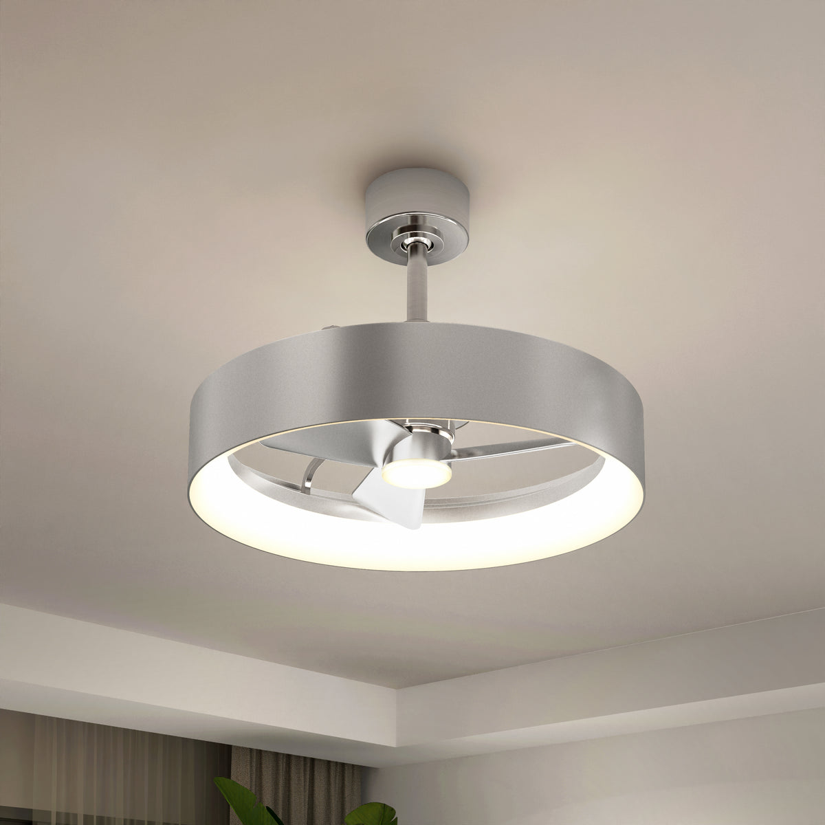 The Artika Austin 23 in. LED modern ceiling fan, featuring a circular silver fixture and quiet motor, is mounted on a white ceiling in a contemporary room with minimal decor. Includes remote control.