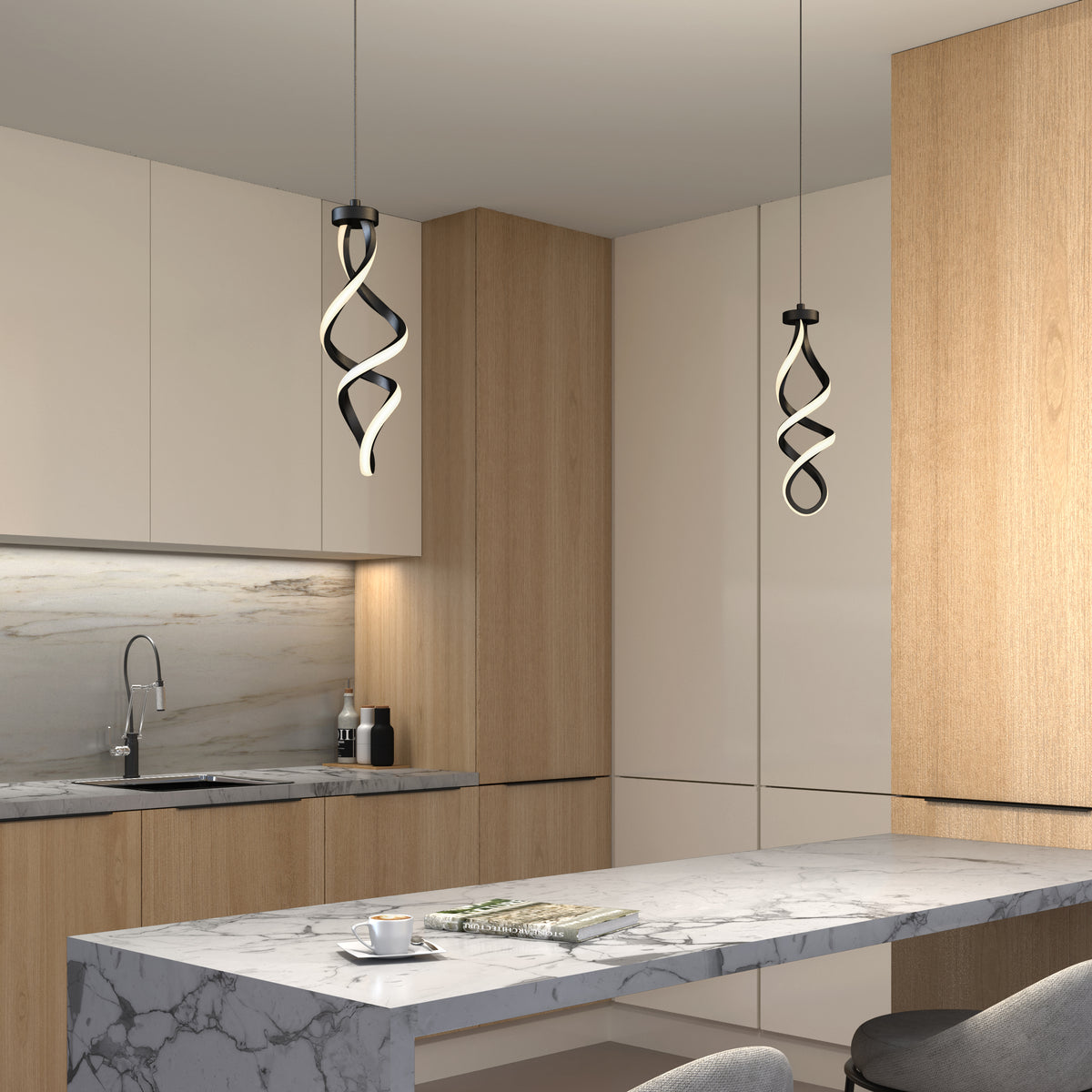 Modern kitchen with light wood and white cabinets, a marble island, and two Artika Mini Swirl LED pendant lights overhead. A cup and open book sit on the island, with a sink visible in the background.