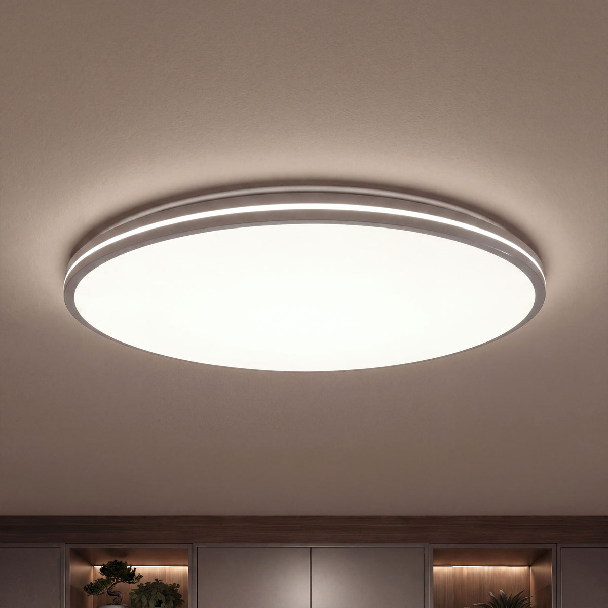 Artika’s GLOW 30 in. LED Flush Mount Ceiling Light with 5 CCT and remote shines over wooden shelves and plants in a modern room.