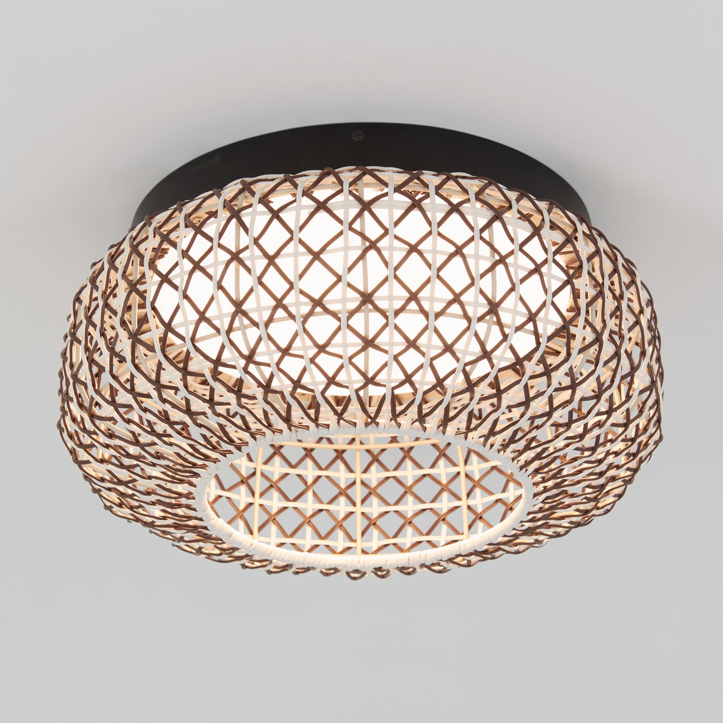 The Artika Benson 15 in. LED flush mount light features a round, woven rattan shade with a visible inner white diffuser and lattice pattern, mounted flush to a plain white ceiling. Offers 5 CCT options for customizable lighting.