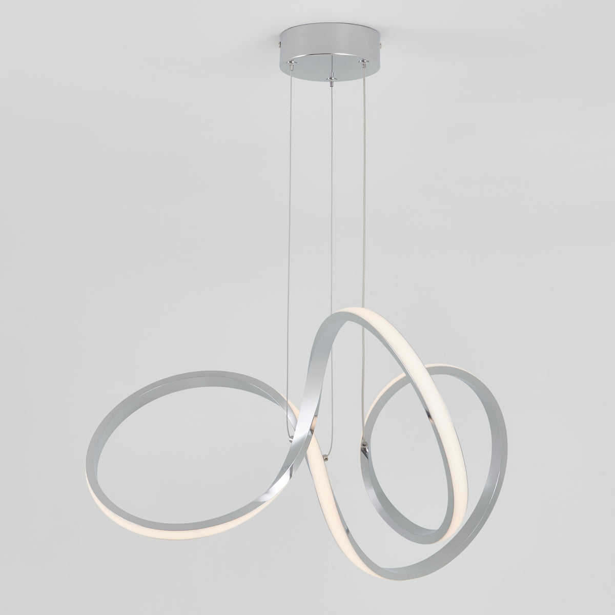 The Artika Swirl LED pendant light features intertwined metallic rings with integrated LED lighting, suspended from a round ceiling mount for a contemporary look.