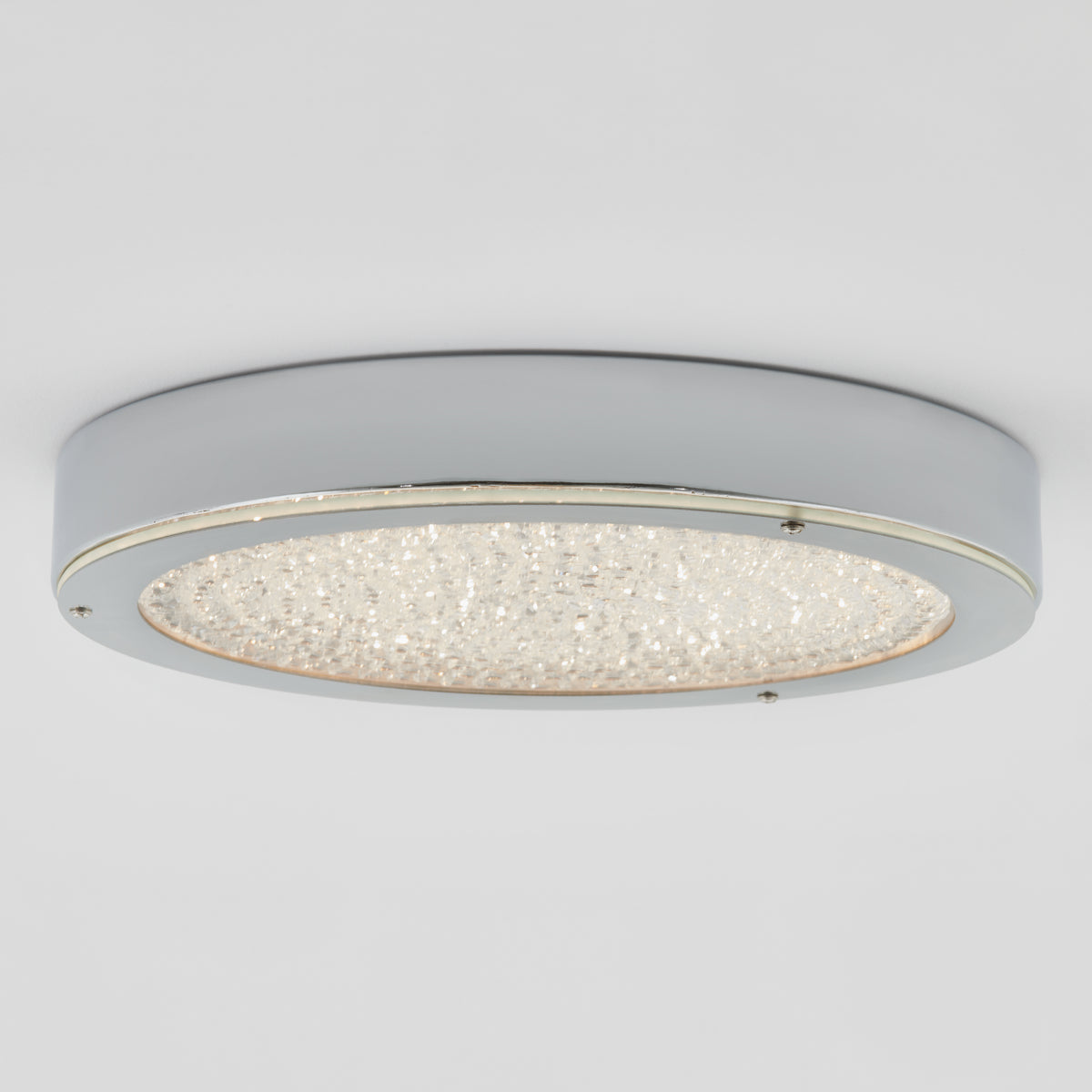 The Artika Glitter LED flush mount is a modern, round chrome light with a frosted glass center for energy-saving style.