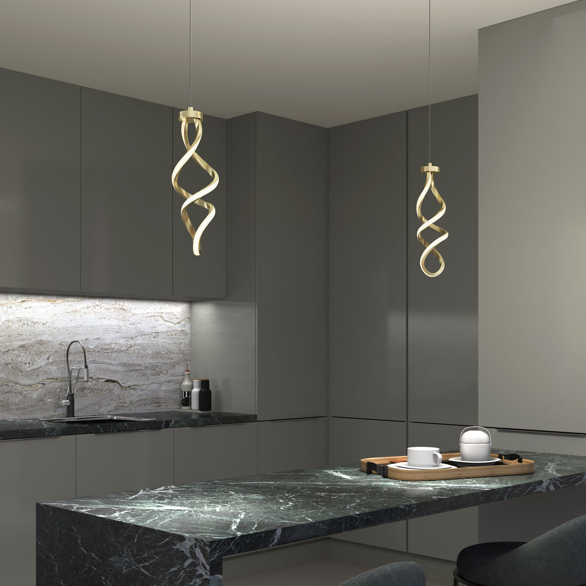A modern kitchen with dark gray cabinets, marble countertops, and a matching backsplash features two Artika Mini Swirl LED pendant lights above the island, which is set with a wooden tray, teapot, and cups.