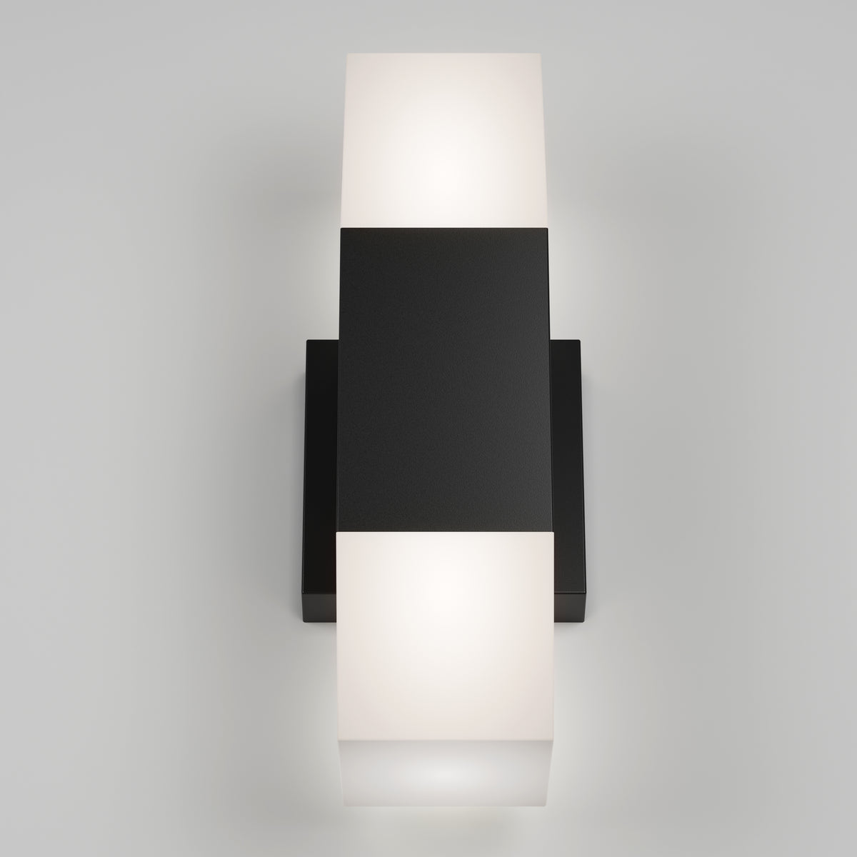 The Artika Lennox indoor-outdoor LED wall light 3 CCT features a black rectangular center and frosted white glass diffusers on both ends, emitting a soft glow from the top and bottom when mounted on a white wall.