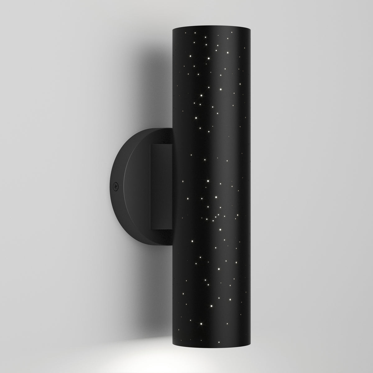The Artika Cosmic indoor-outdoor LED wall light 3 CCT is a black cylindrical sconce with star-like perforations on a round base, casting light through tiny holes for a striking effect against any wall.