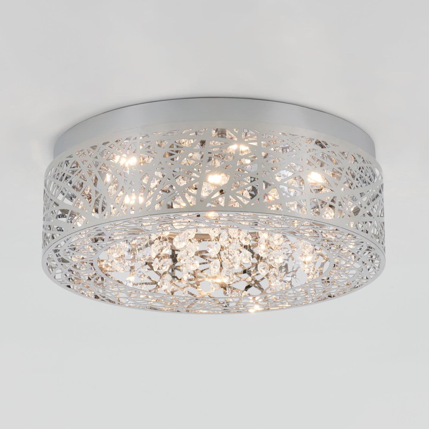 The Artika Crystal Nest LED flush mount is a modern ceiling light featuring a silver geometric lattice and hanging crystal accents, illuminated by multiple small bulbs.