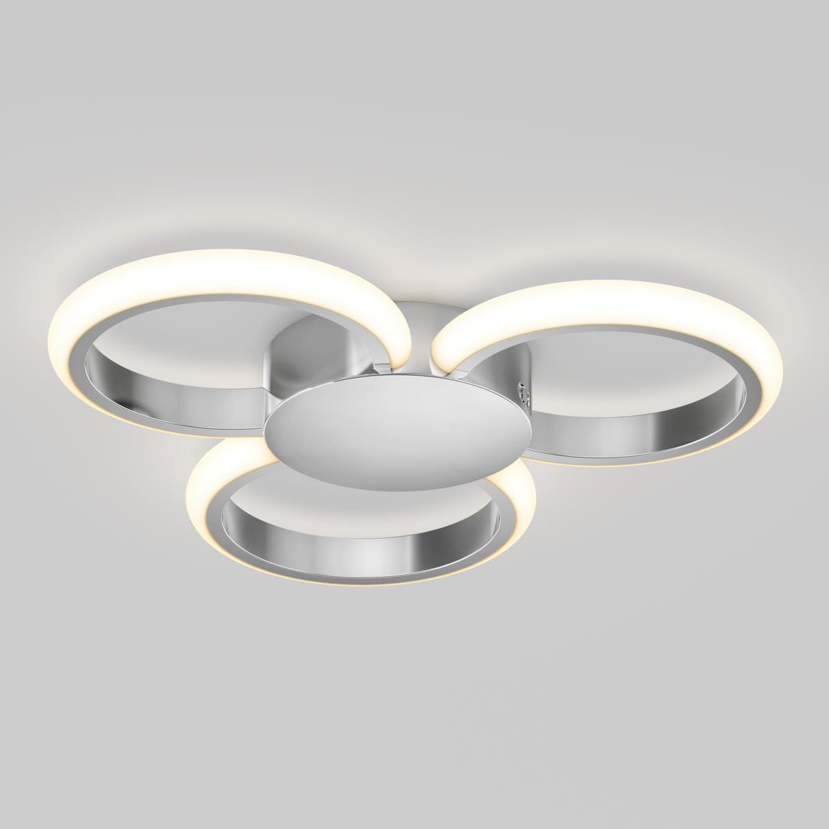 The Artika Nyala 15 in. LED flush mount light features three circular LED rings emitting soft white light, arranged in a triangular pattern on a central metallic base.