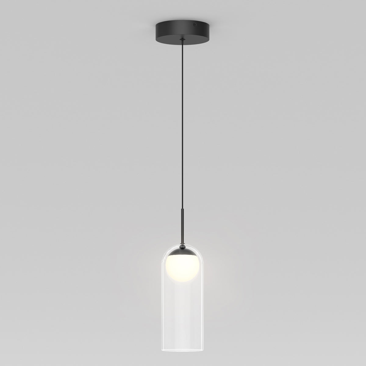 The Artika Mirah LED modern mid-century pendant light 3 CCT features a black ceiling mount and cord with a clear cylindrical glass shade around a glowing white bulb, shown against a plain gray background.
