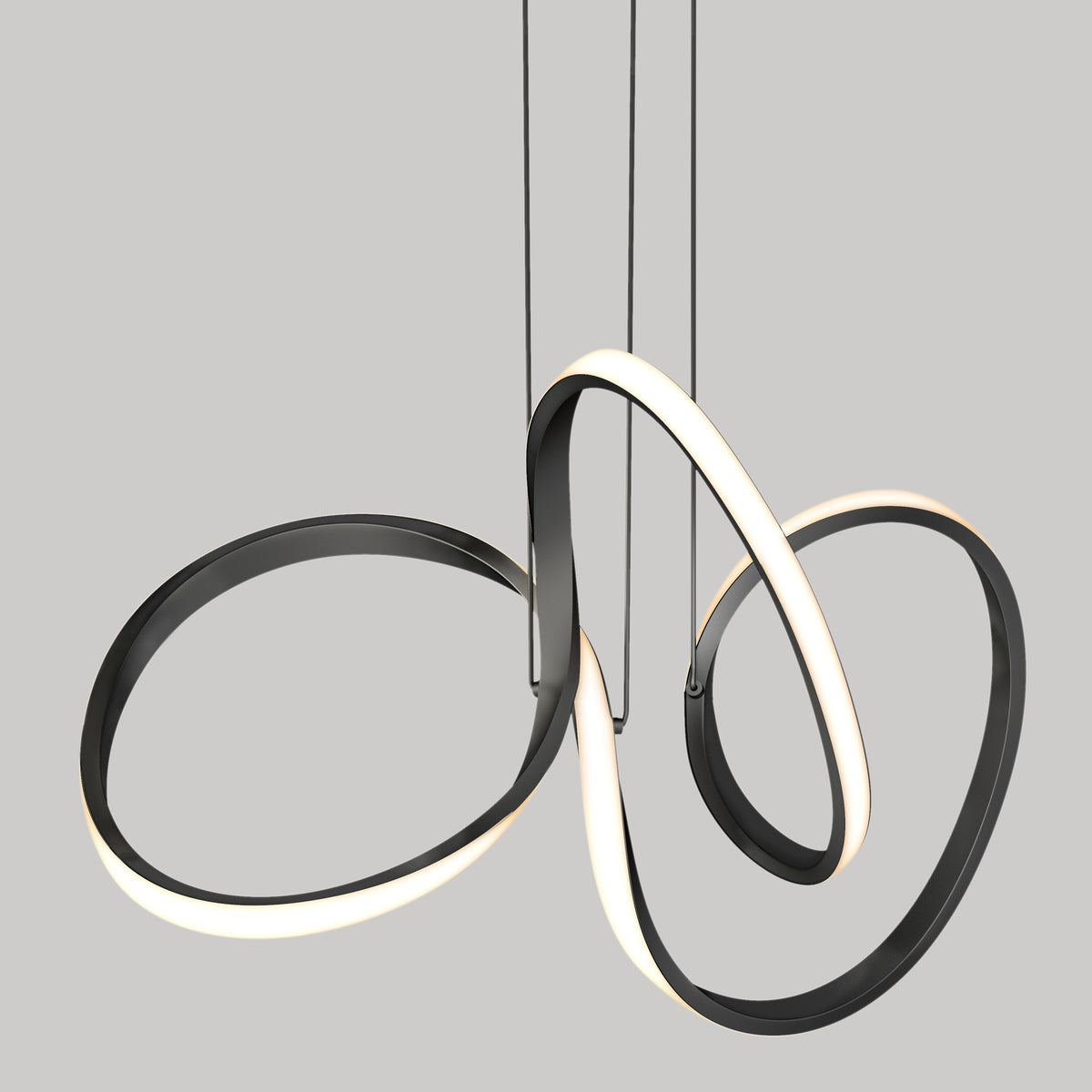 The Swirl LED pendant light by Artika features modern, sculptural black and white intertwined loops suspended by thin cables against a plain gray background.