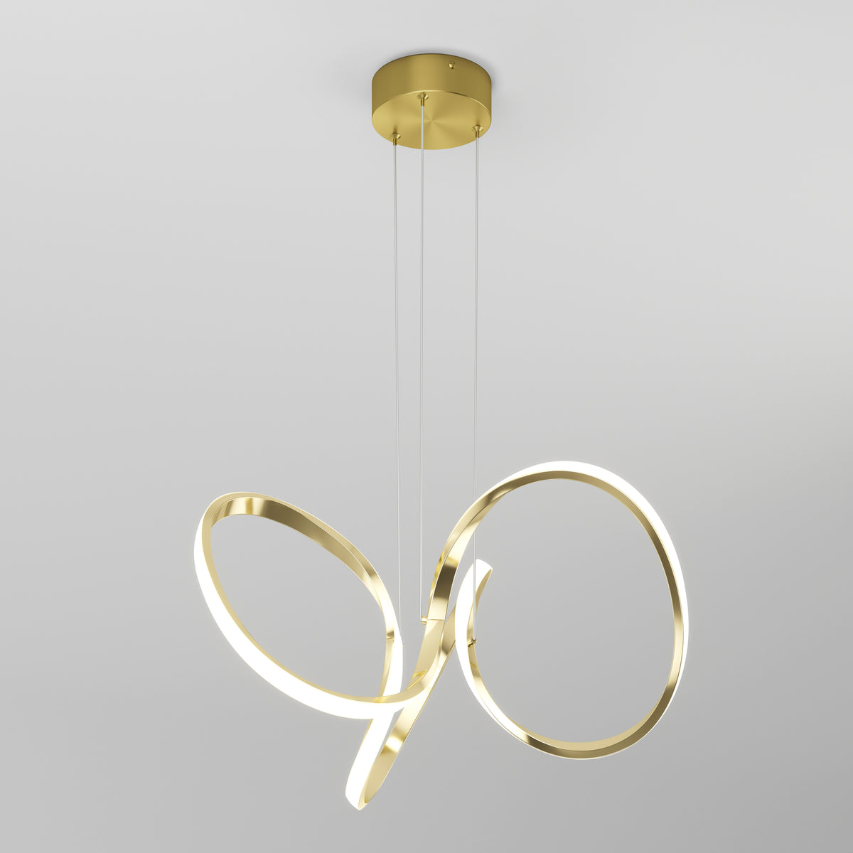 The Artika Swirl LED pendant light features gold, ribbon-like loops with integrated energy-efficient LEDs, suspended by three thin wires from a round gold ceiling mount against a plain light gray background.
