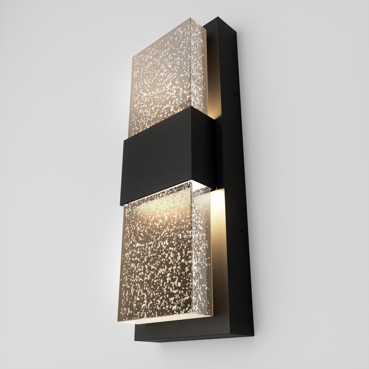 The Mazza Bubble indoor-outdoor LED wall light by Artika features two speckled frosted glass panels divided by a black rectangular metal band, all mounted on a black backplate against a light gray wall.