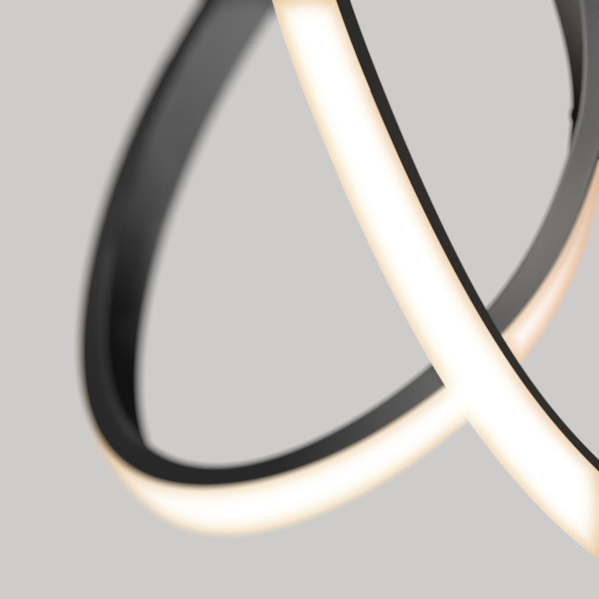 A close-up of the Artika Swirl LED pendant light shows its modern, abstract design with curved, overlapping black and glowing white LED strips set against a plain grey background.