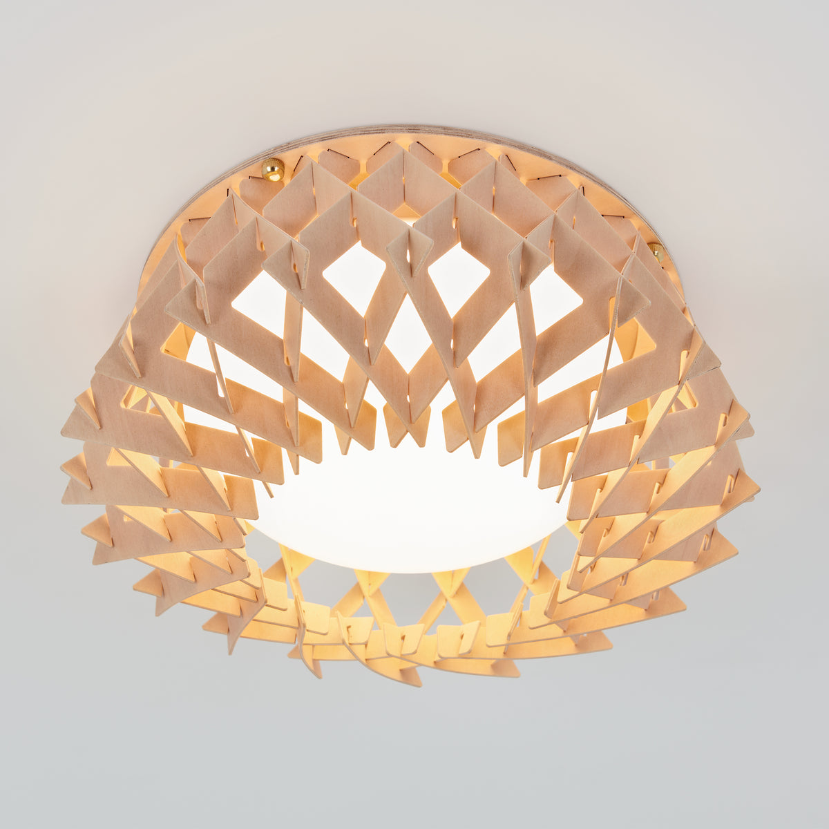 The Artika Kiran 13 in. modern LED flush mount light features a geometric, lattice-patterned wooden shade around a glowing white bulb, and is designed for easy installation on a white ceiling with 5 selectable color temperatures (CCT).