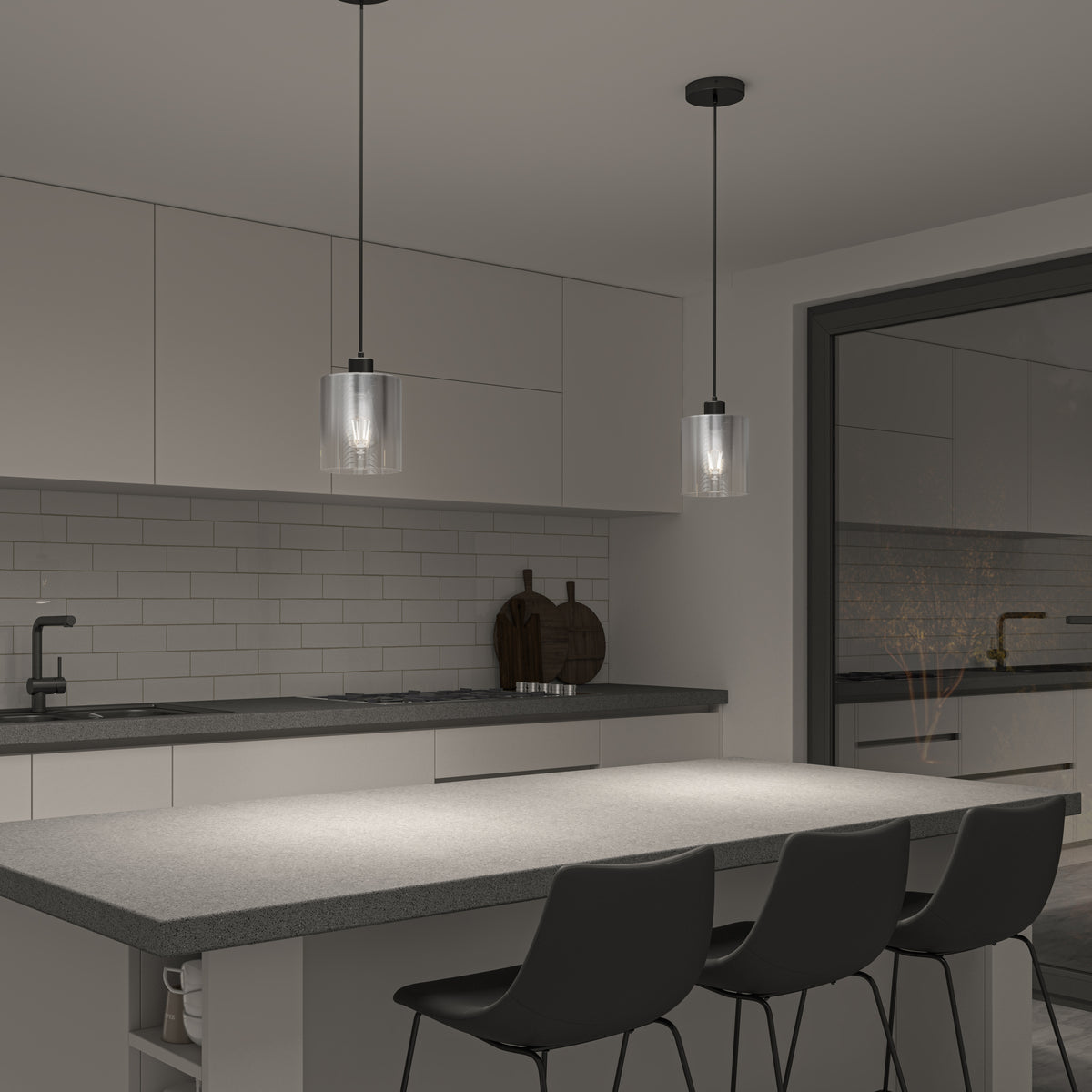 Modern kitchen with a gray island, three black chairs, white cabinets, and two Artika Haze glass pendant lights. Features a subway tile backsplash, sink, and large window showing another room.