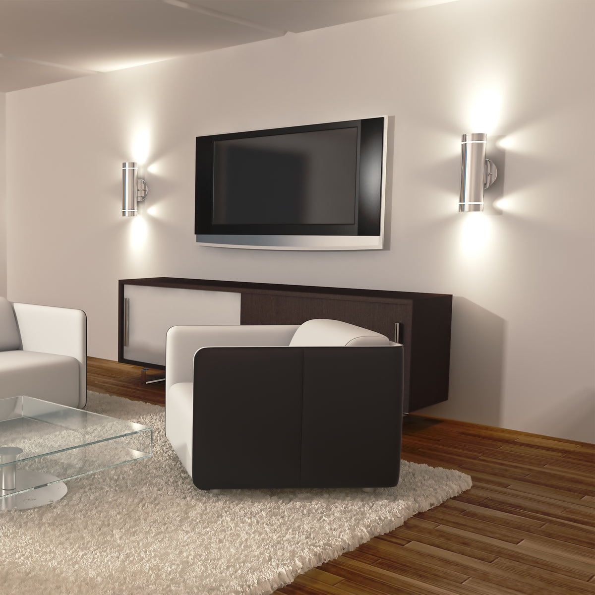 Modern living room with a wall-mounted flat-screen TV, two Artika C7 indoor-outdoor wall lights, dark wood console, white armchairs, glass coffee table, light rug, and hardwood flooring.