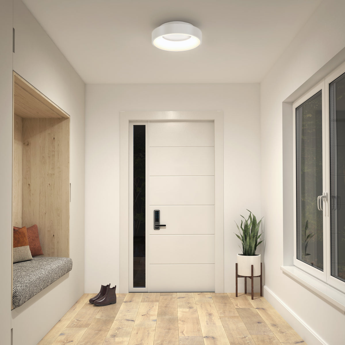 A modern entryway featuring wood flooring, a white door, a built-in bench with pillows, a potted plant on a stand, brown shoes on the floor, and bright illumination from the Artika Aiden LED flush mount ceiling light.