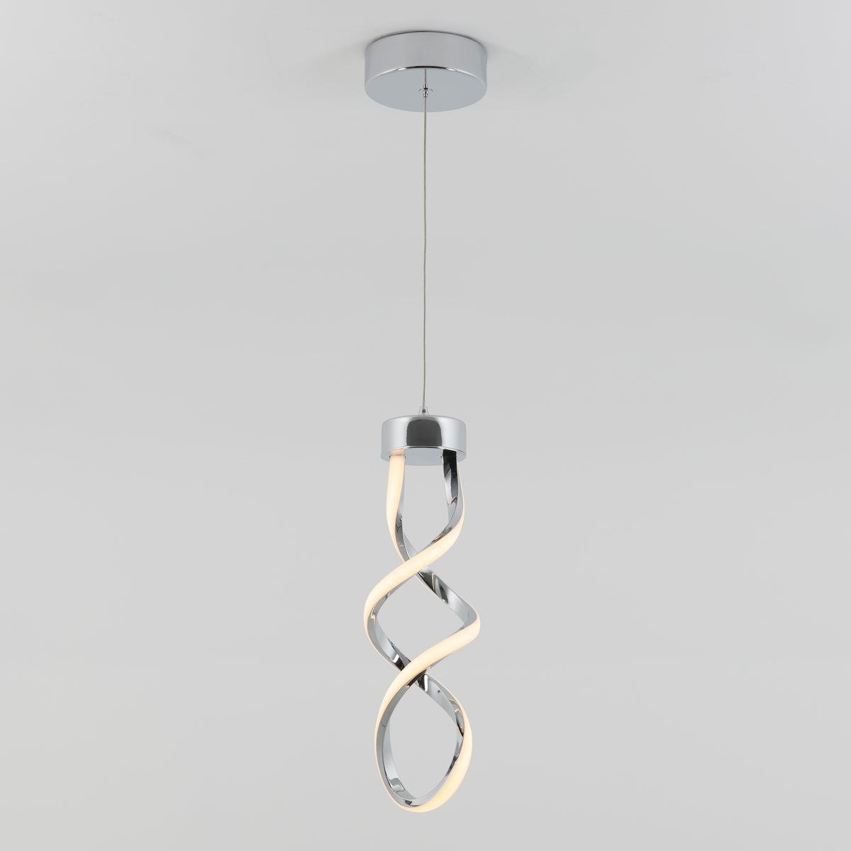 The Artika Mini Swirl LED pendant light features a twisted spiral design with a chrome finish, suspended by a thin wire, and emits a soft white glow from one side.