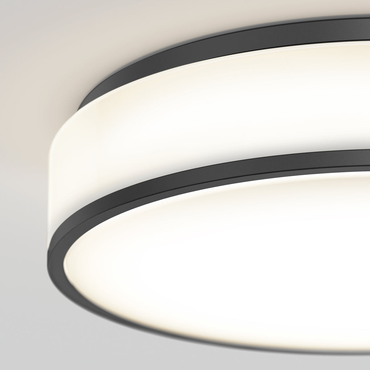 Close-up of the Artika Giada 15 in. LED modern flush mount light with a matte black frame and frosted white diffuser, emitting a soft, even glow. Features 5 CCT settings for customizable lighting.