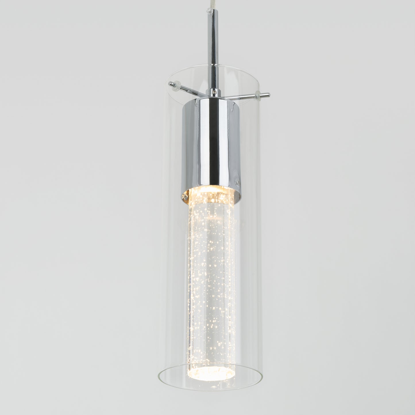 The Artika Bubble Flow 1-light pendant 2 features a modern cylindrical glass shade with chrome accents and an inner frosted tube filled with bubbles, all suspended against a plain light gray background.