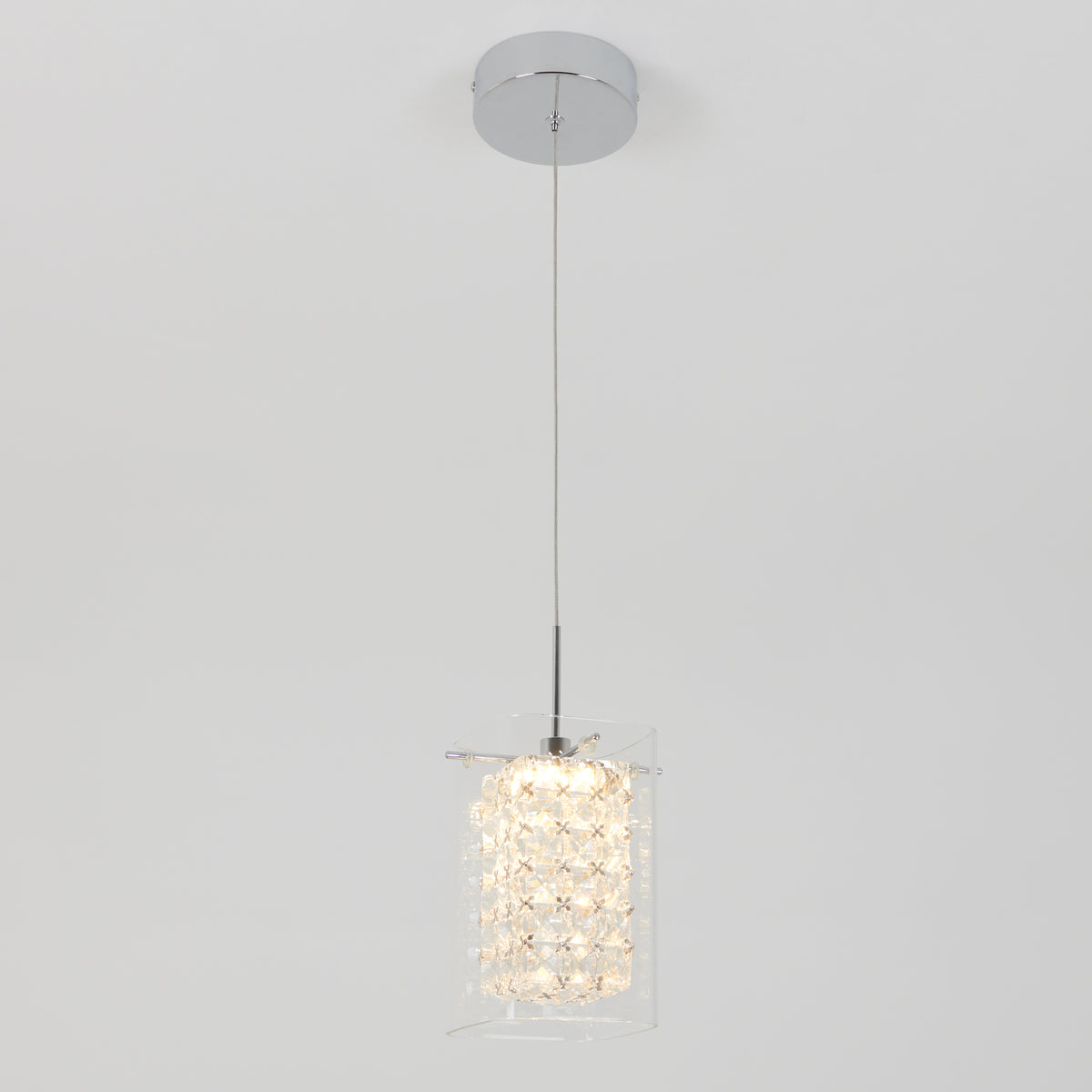 The Artika Crystal Cube 1-light LED pendant light features a chrome ceiling mount, a single cord, and a textured crystal-like cylindrical glass shade, shown illuminated against a plain white background.