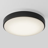 A modern, round ceiling light fixture with a black outer ring and a white, frosted diffuser, mounted on a white ceiling.