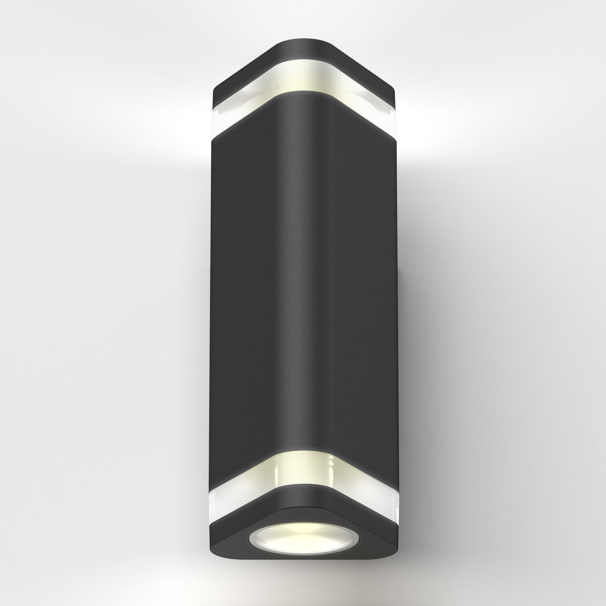 A modern, black, cylindrical wall light fixture with white frosted accents, emitting light from both the top and bottom, mounted on a plain white wall.