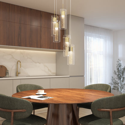 Modern dining area featuring a round wooden table, four green upholstered chairs, a cup and saucer, wood and marble cabinets, gold faucet, and the Artika Essence 5-light LED pendant illuminating overhead.