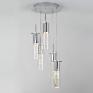 The Artika Bubble Swirl 5-light pendant features five cylindrical glass pendants with bubble details, suspended at varying heights from a round silver base, creating a soft, warm glow.