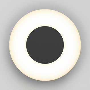 The Artika Ludwig modern LED indoor-outdoor wall light 5CCT features a black central disk encircled by a glowing white ring, shown from above against a plain light gray background.