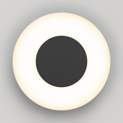 The Artika Ludwig modern LED indoor-outdoor wall light 5CCT features a black central disk encircled by a glowing white ring, shown from above against a plain light gray background.