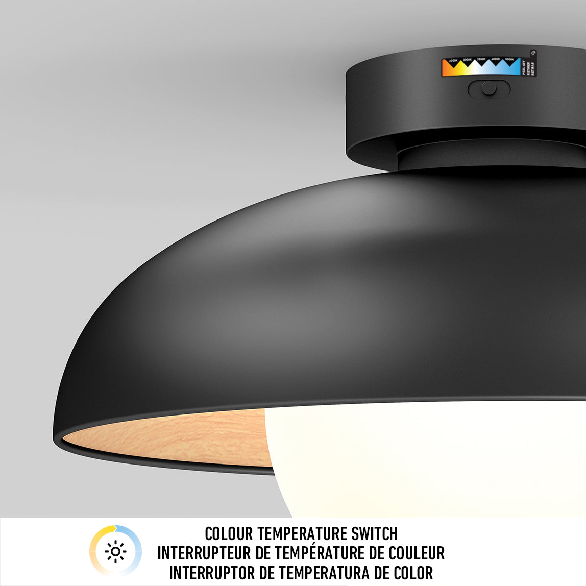 A close-up of a modern black ceiling light fixture with a visible colour temperature switch on the base. A label below describes the switch in English and French.