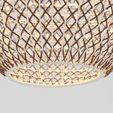 Close-up of a woven, basket-like lampshade made of interlaced brown and white materials, with light shining through the geometric pattern against a plain background.