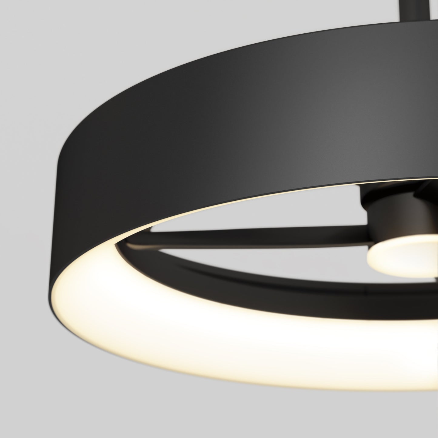 Close-up of the Artika-CAN-dev Austin 23 in. LED modern ceiling fan with remote, featuring a circular black design and glowing white inner ring, set against a neutral gray background.