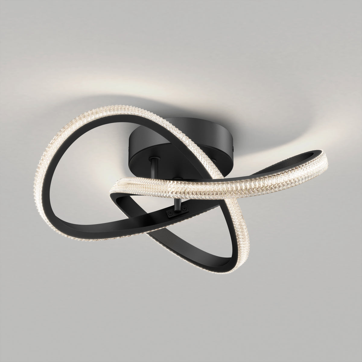 Modern ceiling light fixture with intertwined, looping black arms featuring embedded LED lights, mounted on a round black base against a light gray ceiling.