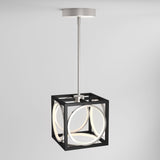 A modern ceiling pendant light featuring a black open cube frame with intersecting illuminated white rings and a silver rod connecting it to a round ceiling mount.