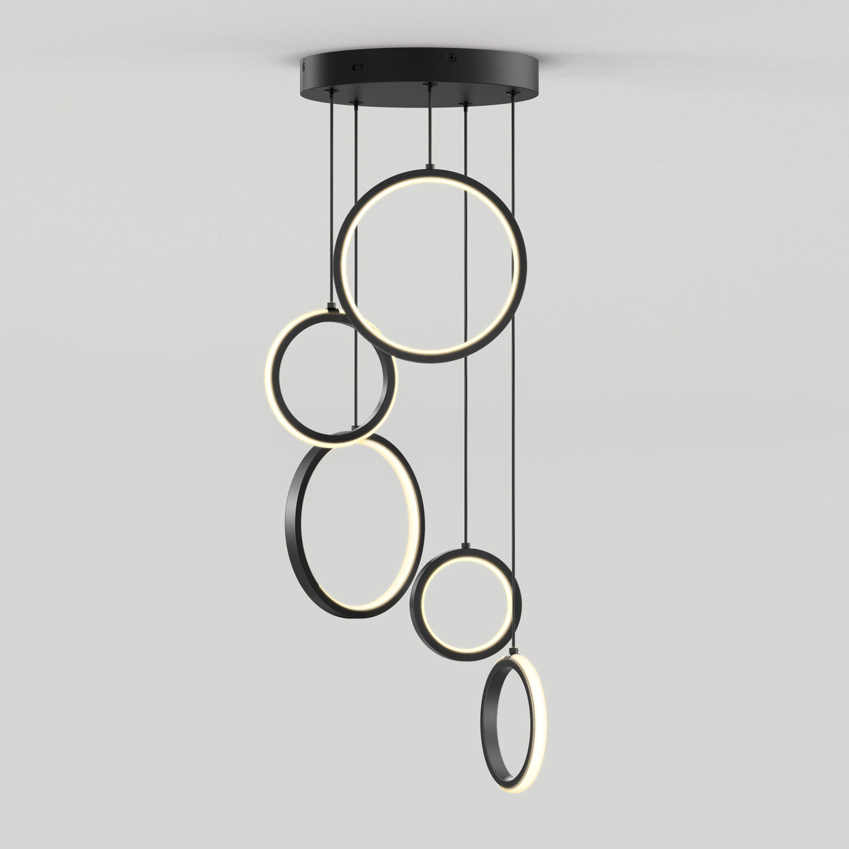 A modern ceiling light fixture featuring five circular LED rings of varying sizes, suspended at different heights from a round black base against a plain white background.
