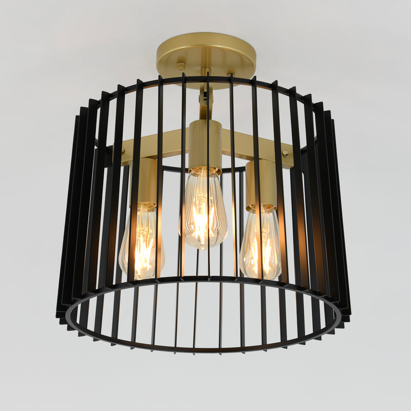 The Artika Gatsby flush mount light features three exposed Edison bulbs with a circular gold base and black vertical metal bars in a cage-like design.