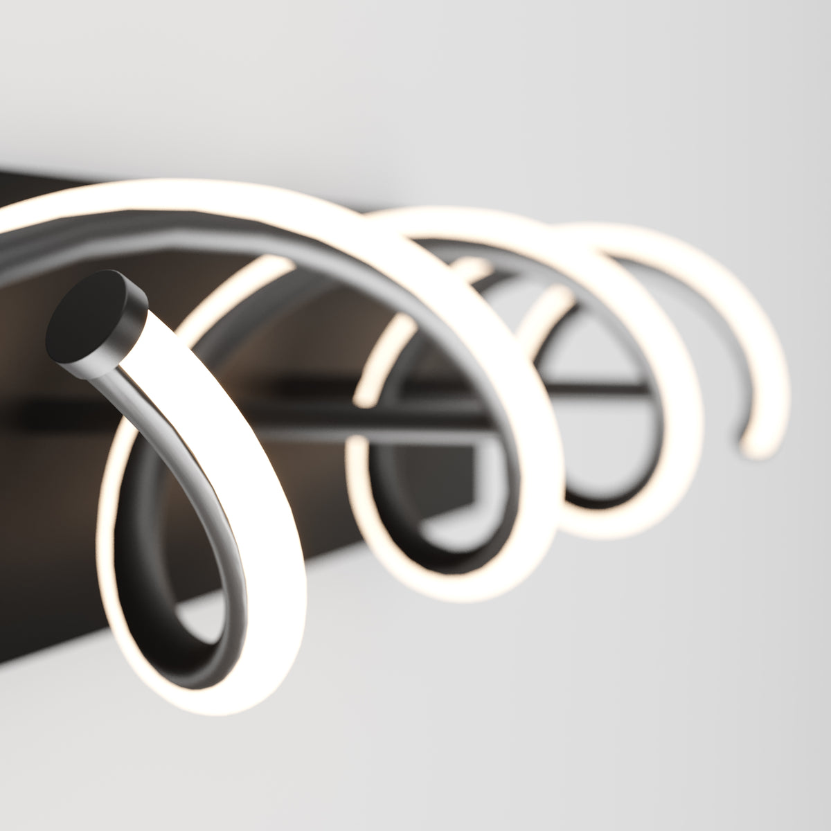 Close-up of a modern wall-mounted light fixture with three curved, glowing LED arms on a black rectangular base, set against a plain white background.