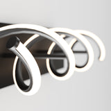 Close-up of a modern wall-mounted light fixture with three curved, glowing LED arms on a black rectangular base, set against a plain white background.