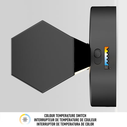 The Artika Ewen modern LED bathroom vanity light 5 CCT, in black hexagonal design, features a visible color temperature switch with a warm-to-cool gradient and trilingual info below in English, French, and Spanish.
