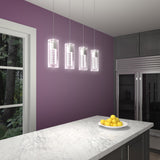 A modern kitchen with a marble island, a plate of lemons, purple walls, hanging pendant lights, grey cabinets, a large fridge, and a window showing trees outside.