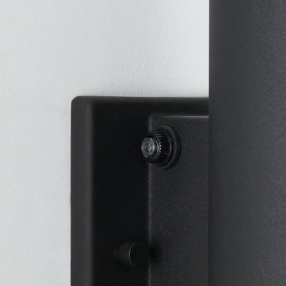Close-up of the Artika Linea modern indoor-outdoor LED wall light, a black wall-mounted fixture with two round knob controls—one larger above, one smaller below—shown against a white wall.