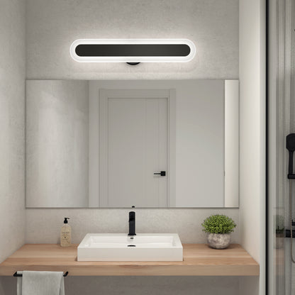 A minimalistic bathroom features a wooden countertop, white rectangular sink, soap dispenser, potted plant, large mirror with towel, and the Artika Pista modern LED bathroom vanity light 5 CCT above it. Walls and door are white.