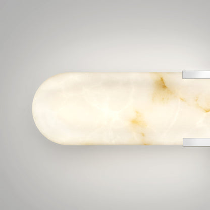 The Artika Selena 3 CCT LED bathroom vanity light features a rounded rectangular white marble shade with subtle brown veining, mounted on a light grey wall with two silver brackets.
