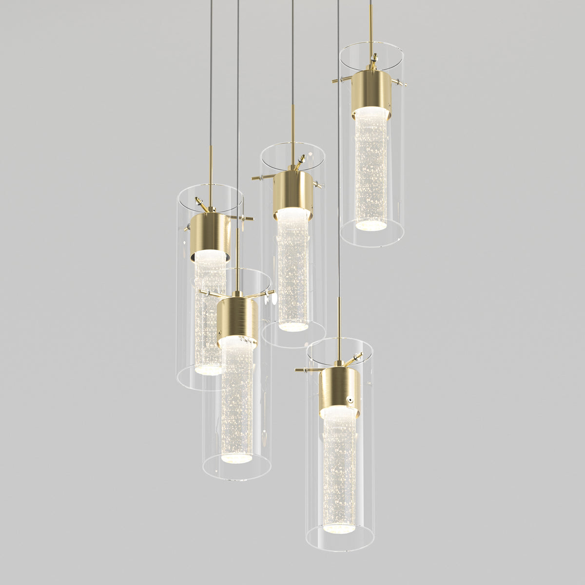 Cluster of five modern pendant lights with gold accents, cylindrical clear glass shades, and textured glass diffusers, suspended at varying heights against a plain light gray background.