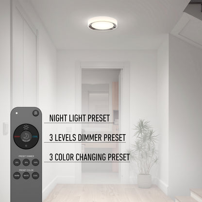 The Artika Cooper LED flush mount light with remote is displayed in a minimal hallway. Features—night light, 3-level dimmer, and 3 color presets—are highlighted. A plant sits by the door.